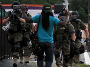 Riot police in combat gear confront a demonstrator in Ferguson, Missouri.
